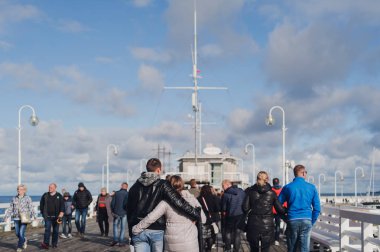 Sopot, Polonya - 6 Ekim 2019: Kucaklanan çiftler Polonya 'nın Sopot kentinde ana iskele boyunca yürüyorlar.