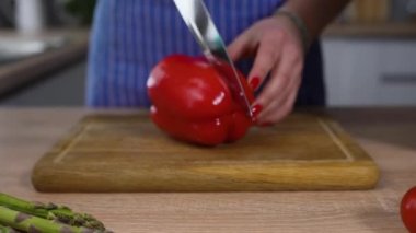 Yemek pişirmek için masaya kırmızı biber dilimliyorum. 