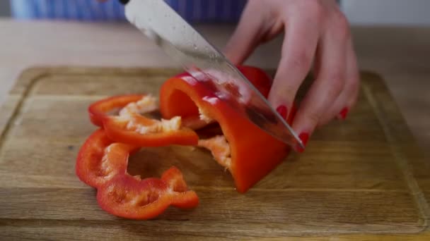 Trancher le poivron rouge pour la salade sur la table — Video