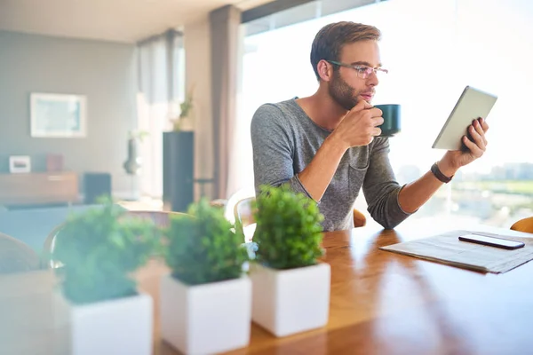 Apuesto joven arquitecto europeo bebiendo café y leyendo en casa —  Fotos de Stock