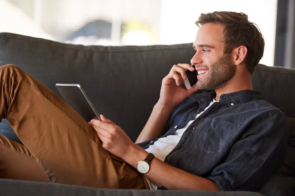 Feliz hombre cucasiano sonriendo en el teléfono mientras sostiene la tableta Fotos De Stock