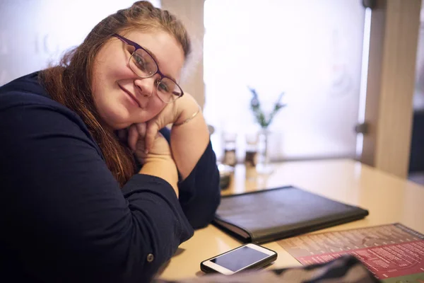 Chubby teacher sitting in a bright coffee shop Stock Image
