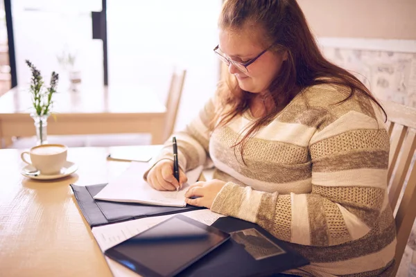 Plus Size Geschäftsfrau, die in einem lokalen Café arbeitet Stockfoto