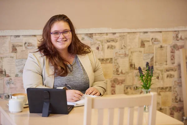 Plus size caucasian businesswoman smiling at camera in coffee shop — Stock Photo, Image