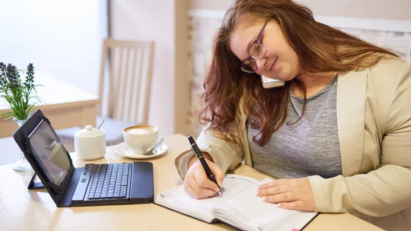 Attractive plus size business woman working in bright coffee shop — Stock Photo, Image