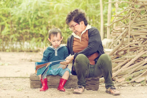 Matka Učí Dítě Číst Knihu Venku — Stock fotografie