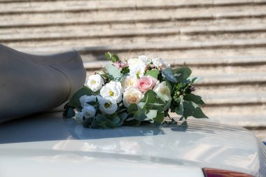 Çiçek buketi, beyaz ve renkli güllerle düğün günü gelin ve damat arabası dekorasyonu için kullanılıyor. İtalya, Sicilya.