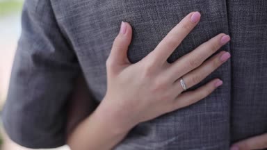 Ağır çekim sığ dof pahalı giysi takı yüzük arka sevecen adam okşayarak kadın el yakın. Kadın gelin damat bel tutan doğa arka plan defocused. Düğün moda aşk ilişkisi