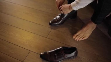 Erkek el şık tasarımcı Ayakkabı karanlık tespitleme koyarak hiçbir yüz çıplak ayak ağır çekim renk. Festival yepyeni ayakkabı giyen tanınmayan adam kapatmak kapalı doğal hafif ticari biçemi