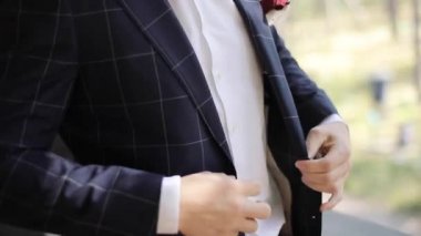 Tanınmayan akıllı adam kapalı olay için hazırlanıyor siyah damalı takım koyarak kapatın. Erkek tasarımcı kıyafetleri kadar düğmelerini şık ceket ağır çekim giyen eller. Moda erkek giyim