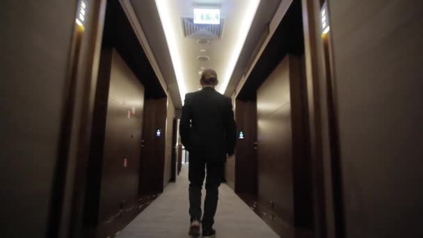 Young Businessman Going Long Narrow Corridor Closed Doors Back View — Stock Video