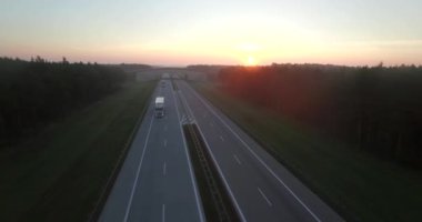 4 k hava görünümünü uçuş kırsal otomobil kamyon kamyon her iki yönde de taşıma karayolu üzerinde. Bölünmüş günlük trafik doğal açık yeşil renkli akşam. Kargo lojistik taşıma