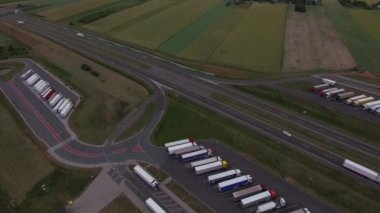Yavaş yavaş dışarı Otoban yol Park çok kamyonet kamyon kırsal akşam ile yakınlaştırma helikopter. 4 k hava yukarıdan aşağıya, dinlenme otomobil kamyon görünümünü kırsal arka plan kes. Kargo teslim lojistik