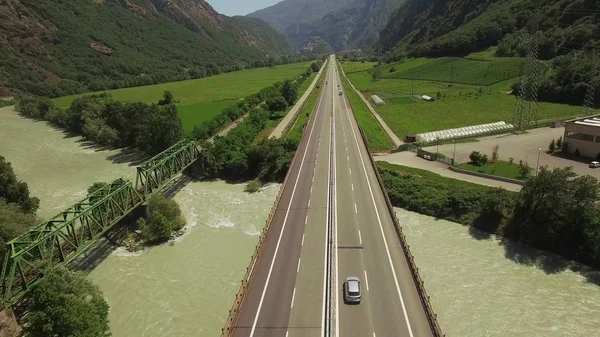 4 k panoramik yukarıdan aşağı asfalt otoyol görünümünü ve bir parça Demiryolu demiryolu dağlık alanda. Trafik akışı Nehri Köprüsü üzerinde uçan Quadcopter dron. Seyahat turizm Lojistik Kargo navlun