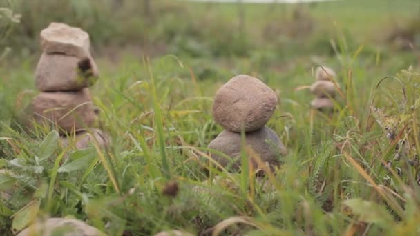 Vrouwelijke Hand Zetten Steen Piramide Top Voor Evenwicht Groene Gras — Stockvideo