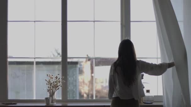 Chica Tirando Las Cortinas Para Mirar Por Ventana Disfrutando Luz — Vídeo de stock