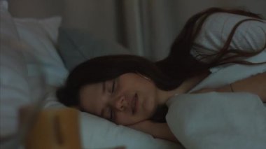 Yorgun kadın yatakta uykuya dalma yakın kadın yüzü 4k gece yüz kozmetik. Yorgun kız beyaz elbisepijama kapalı gözlerle yatarken uyuyor. Kadın güzellik endüstrisi sağlıklı yaşam tarzı