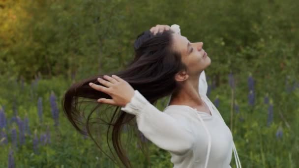 緑の野原でぐるぐる回る自由な自然の女性 若い幸せな女の子は 自然の背景スローモーションを閉じた目で回る ヘアケア製品女性エコロジカル化粧品 — ストック動画