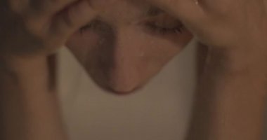 Yüzünde su damlaları ile duş banyosunda kadının yakın portresi. Kız yüzünün üzerinde eller çalışır açık gözleri nefes almak sağlıklı yaşam tarzı konsantrasyonu refah kavramı