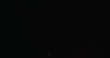 Bonfire kıvılcım gece gökyüzüne uçan defocused. Yuvarlak siyah hava arka planda yavaş hareket yayılır bokeh kıvılcımları. Sihirli turuncu mermi karanlık bir şekilde hareket ediyor. Sarı yangın kaplamanın bulanık çevrelerinde