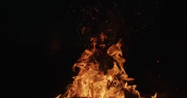 无面的人在火中移动木材 使火花 篝火特写橙色火焰和火花飞向黑色夜空慢动作 宏视频身体舌头的火焰野火能量 — 图库视频影像