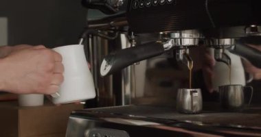 Tanınmayan barista tutucu atıcı ve dumanı tüten süt. Metal Kupadaki Profesyonel Makine 'den kahve akışı. Modern makinede kahve yapma süreci baştan sona kahve dükkanında. 