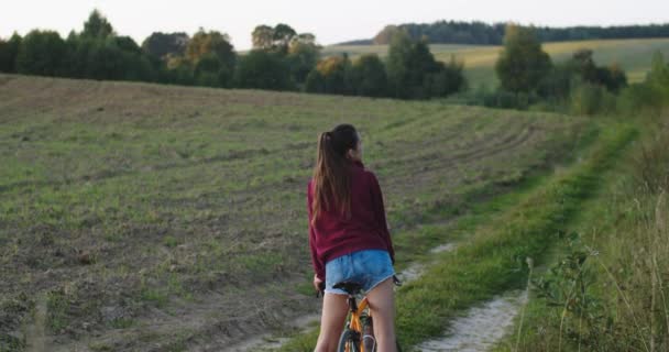 Сексуальна Дівчина Довгими Ногами Стоїть Велосипеді Відкритому Повітрі Сільський Фон — стокове відео