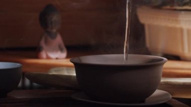 Çin çay fincanının, içinde kuru yapraklar ve yukarıdan akan suyun video görüntülerini kapatın. Seçkin içkiler hazırlayan meçhul kişi özel kil teaware makro görüntüsü sunuyor. Doğu kültürü