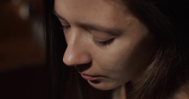 Portrait élégant de fille naturelle profitant d'une boisson chaude à l'intérieur appartement sombre avec des rayons de soleil. Belle femme buvant du thé à partir d'une tasse en céramique close up slow motion. Concentration relaxation méditation 