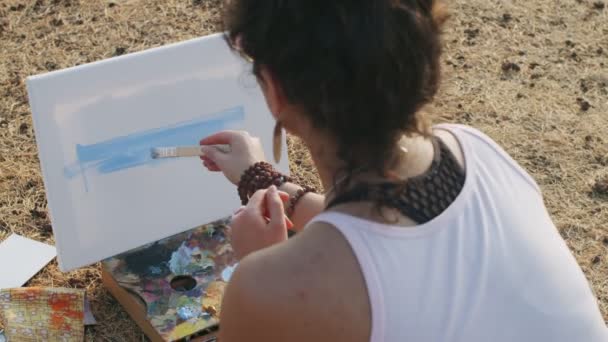 Vue arrière de fille sans visage commençant la peinture avec la couleur bleue en plein air fond de la nature d'été. Artiste féminine méconnaissable travaillant sur toile au ralenti. Processus créatif tutoriel concept artisanal — Video