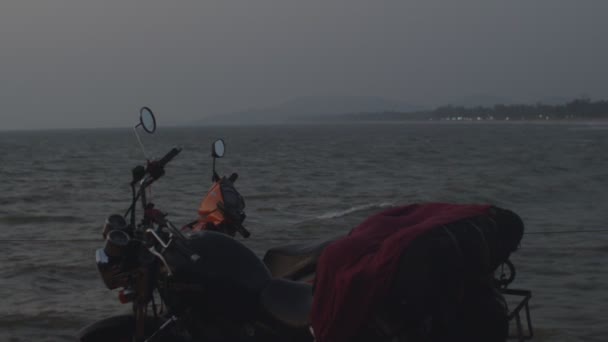 Motorka stojí proti moři při západu slunce. Dvě motorky zaparkované u moře pryč hory a světla na pláži. Večerní motocykl vyjížďky v blízkosti moře dobrodružství a relaxace v Asii — Stock video