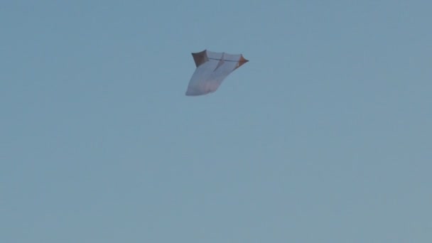 青い雲のない空のコピーテキストスペースで飛行するエアリーホワイトカイト。空気の遅い動きにホバリング無重力おもちゃの低角度ビュー。自由独立の考え方。夏の幸福シンボル — ストック動画