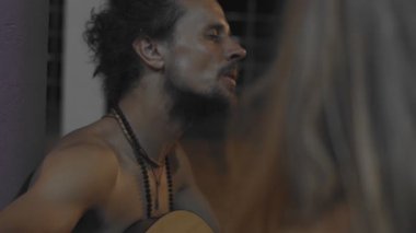Sokak ortasında el bilgisayarı ile gitar çalan otantik hippi müzisyenin yan portresi. Sakallı adam Hindistan 'ın dışında ağır çekimde müzik yapıyor. Gerçek insanların hayat tarzı hikaye anlatımı
