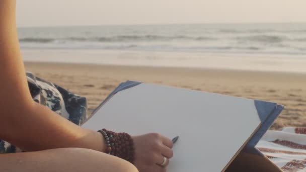 Arctalan művész kezd rajz szabadban homokos tengerparti háttér lassított felvétel. Közelíts női kezekre, akik ceruzarajzot készítenek az óceán partján. Art terápia stressz leküzdeni pihenés nyári vakáció