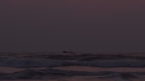 Samotna łódź rybacka pływająca w wzburzonym morzu pośród fal w wieczornym świetle zmierzchu w zwolnionym tempie. Tapeta burzowa na przylądku zaczyna się w nocy, gdy rybacy dryfują na pokładzie. Żeglowanie w złej pogodzie — Wideo stockowe