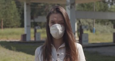 Salgın koruyucu maske takan bir kızın portresi. Terk edilmiş karantina caddesinde duran genç bir kadın kendini ikinci dalga covid virüs enfeksiyonuna karşı koruyor.
