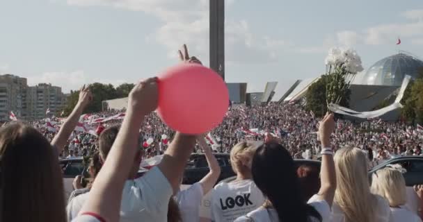 MINSK, BELARUS - 16 sierpnia 2020: Ludzie biorą udział w pokojowym proteście w pobliżu pomnika. Ludzie z kwiatami i flagami na demonstracjach przeciwko dyktaturze. Białorusini Żądanie zatrzymać przemoc — Wideo stockowe