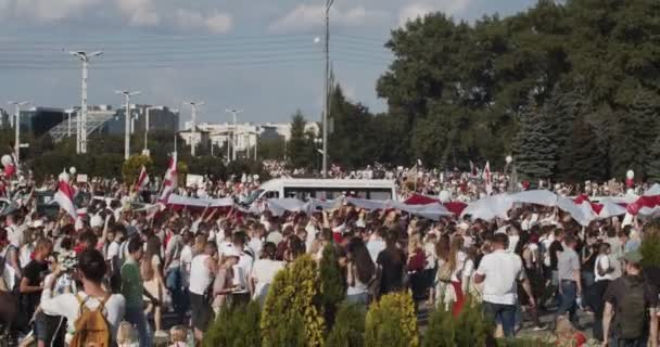 MINSK, BELARUS - 16 ΑΥΓΟΥΣΤΟΥ 2020: Οι άνθρωποι κουβαλούν τη γιγάντια άσπρη-κόκκινη-άσπρη ιστορική σημαία κάτω από την οδό. Λευκορώσοι έλαβαν μέρος σε διαδηλώσεις κατά της δικτατορίας του Alexander Lukashenko — Αρχείο Βίντεο