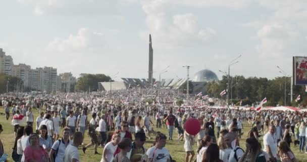 MINSK, BÉLARO - 16 de agosto de 2020: La gente participa en una protesta pacífica cerca del monumento. Personas con flores y banderas en manifestaciones contra la dictadura. Bielorrusos exigen detener la violencia — Vídeos de Stock