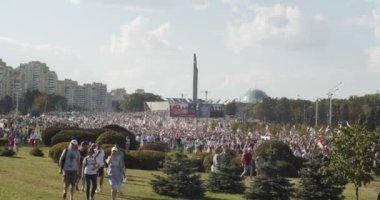 MINSK, BELARUS - 16 AĞUSTOS 2020: insanlar anıtın yakınındaki barışçıl protestolara katılıyor. Çiçekleri ve bayrakları olan insanlar diktatörlüğe karşı gösteri yapıyorlar. Belaruslular Şiddeti Durdurun