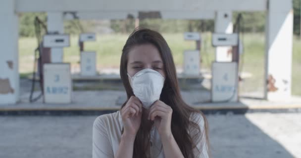 Feche o retrato da menina caucasiana tirando a máscara anti-vírus pandêmica em câmera lenta. Mulher feliz respirando ar fresco e saudável durante a quarentena ao ar livre. Protecção médica conceito de cuidados de saúde — Vídeo de Stock