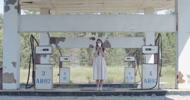 Mujer joven quitándose la máscara protectora pandémica en el fondo abandonado de la gasolinera. Chica feliz respirando aire fresco en la calle de cuarentena vacía cámara lenta. Infección por el virus covid de segunda ola — Vídeos de Stock