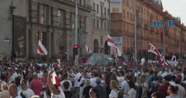 Беларусь - 16 августа 2020 года: Мирные протестующие с плакатами и флагами движутся по улицам города. Белорусы приняли участие в демонстрациях в Беларуси против диктатуры Александра Лукашенко — стоковое видео