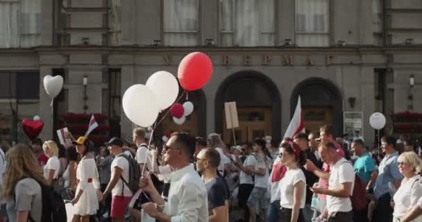 Беларусь - 16 августа 2020 года: Мирные протестующие с плакатами и флагами движутся по улицам города. Белорусы приняли участие в демонстрациях в Беларуси против диктатуры Александра Лукашенко — стоковое видео