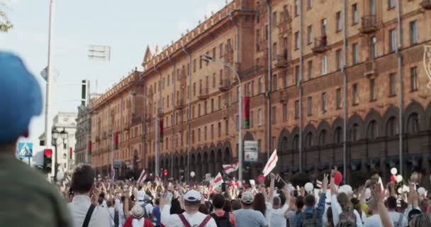 2014 년 8 월 16 일에 확인 함 . MINSK, BeliARUS - AUGeight 16, 2020: Peaceful Protesters With Posters And Flags move along Street City. 벨라루스인들이 러시아의 독재자 알렉산드르 루카셴코에 대항하는 시위에 참여하다 — 비디오