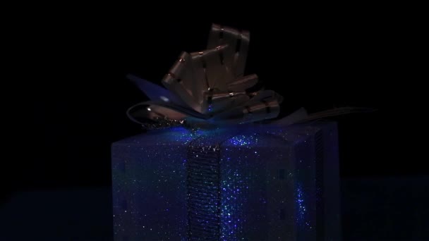 Farbige Geschenkbox Über Lichtern Auf Schwarzem Hintergrund — Stockvideo