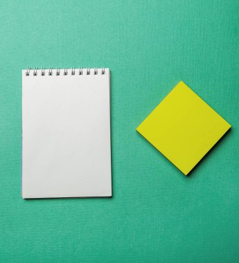 yeşil arkaplanda beyaz boş not defteri
