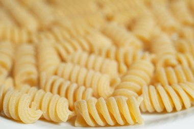 beyaz yüzeyüzerinde çiğ pişmemiş makarna yığını 