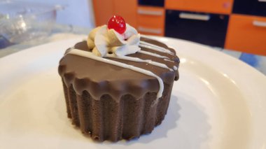 Lezzetli çikolatalı pasta, üstünde reçel ve krema.