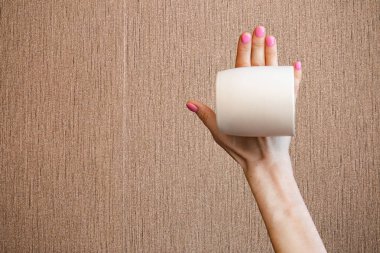 Kahverengi arka planda boş beyaz bardağı tutan kadının yakın plan görüntüsü